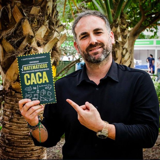 Santi García Cremades sostiene su libro Enigmas matemáticos para resolver mientras haces caca
