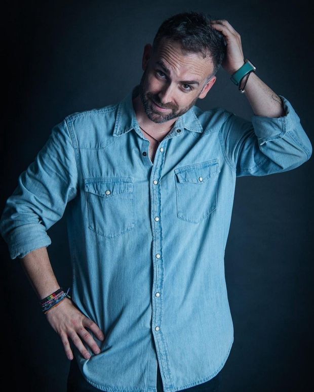 Retrato de Santi García Cremades con camisa vaquera sobre fondo oscuro