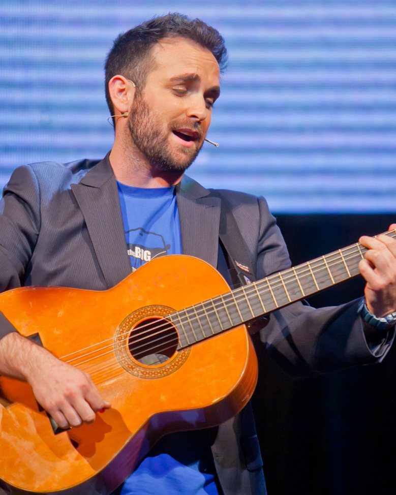 Santi García Cremades cantando con la guitarra en un escenario
