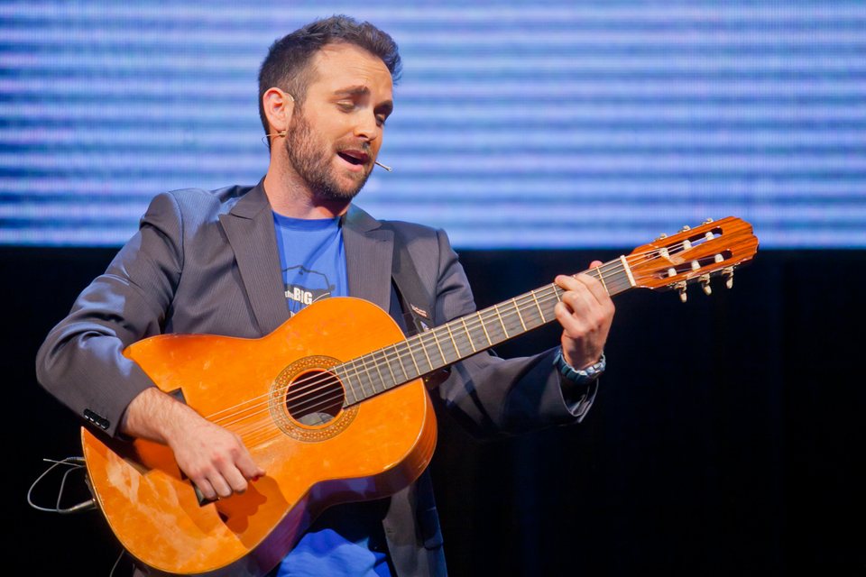 Santi García Cremades canta con la guitarra sobre un escenario